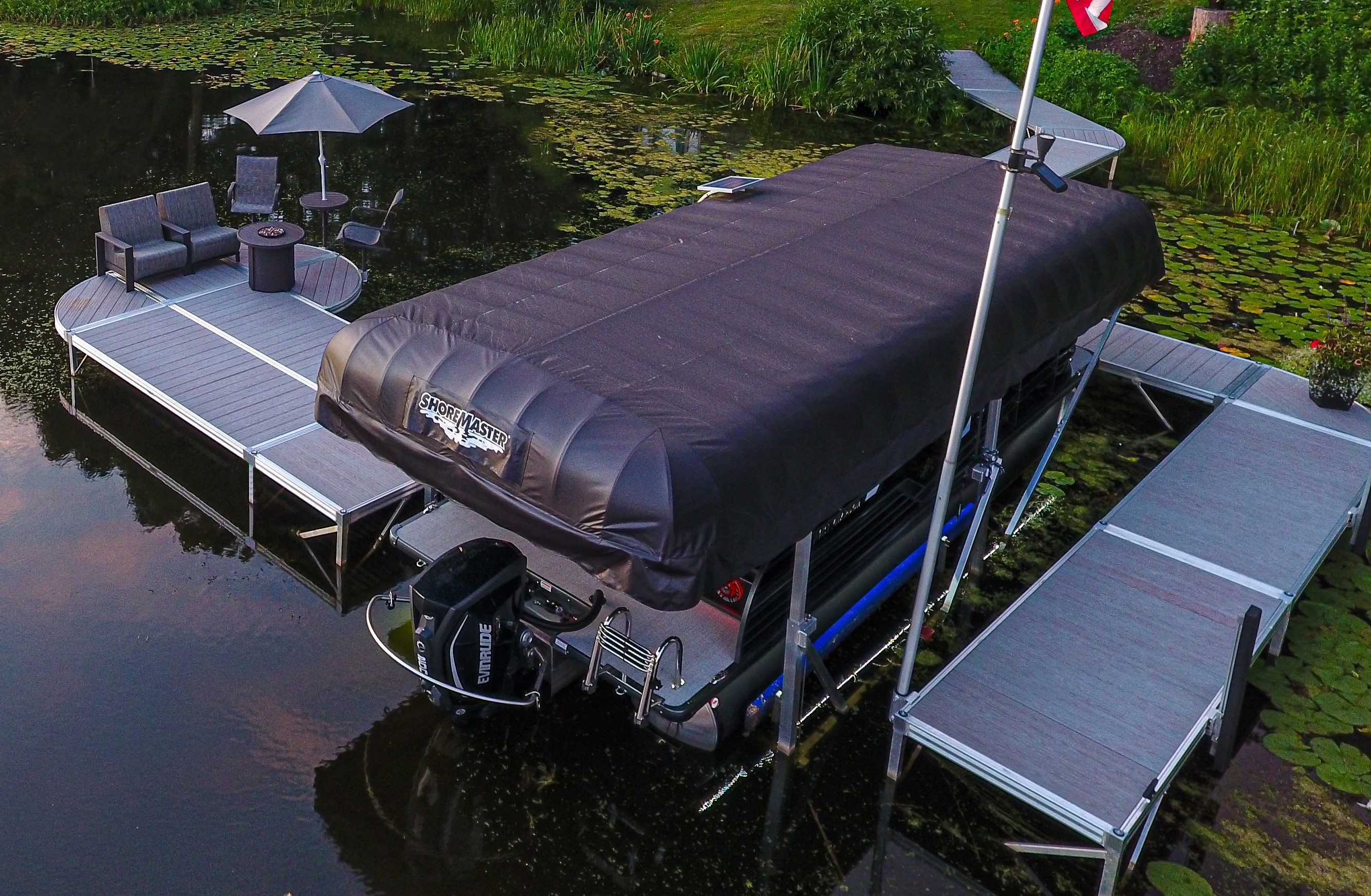 A pontoon boat with a cover on the dock